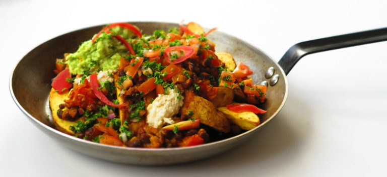 Mexican loaded nacho wedges with pico de gallo, sour cream and guacamole