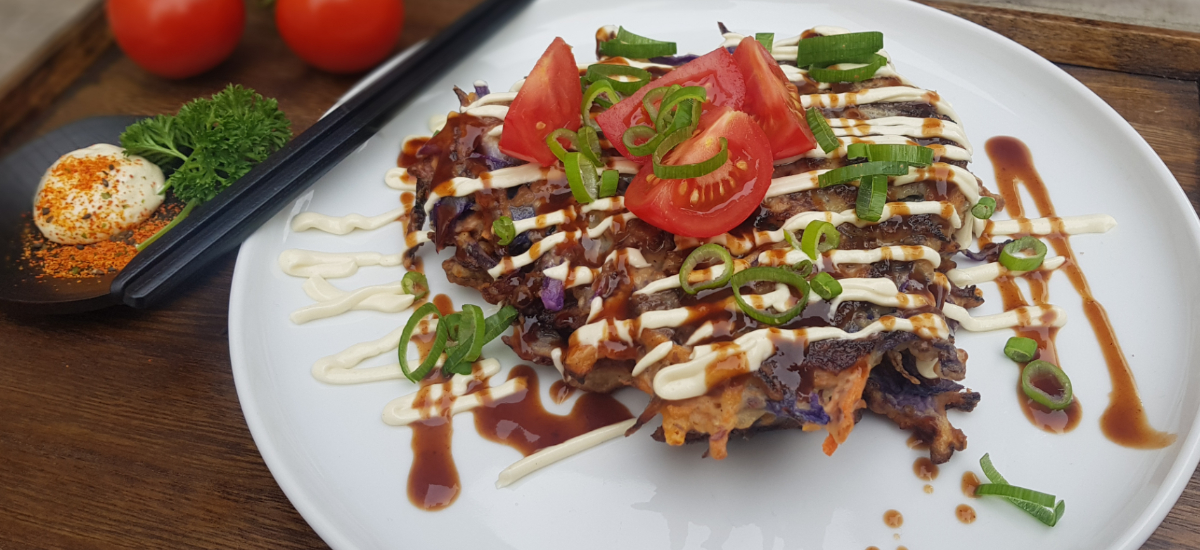 Japanese pancake with okonomiyaki sauce, mayo and tomato salad with sesame dressing