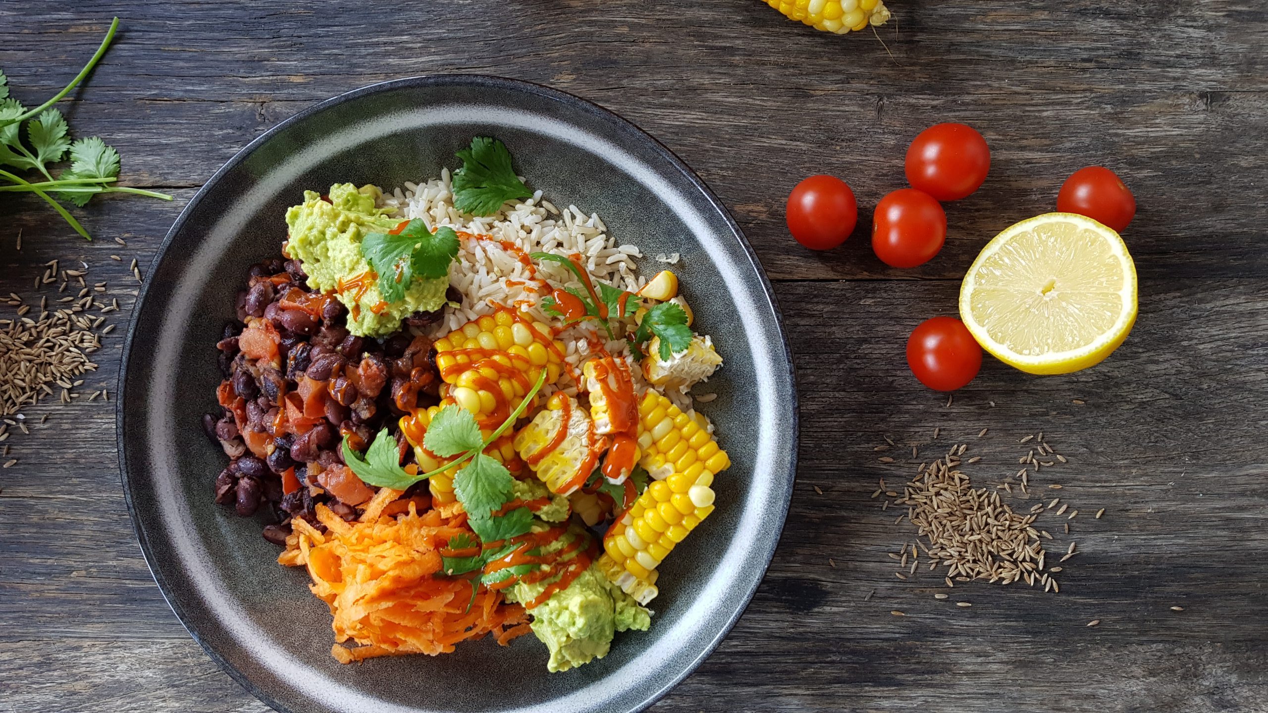 Roast corn burrito bowl with smashed avocado, spicy kidney beans and brown rice