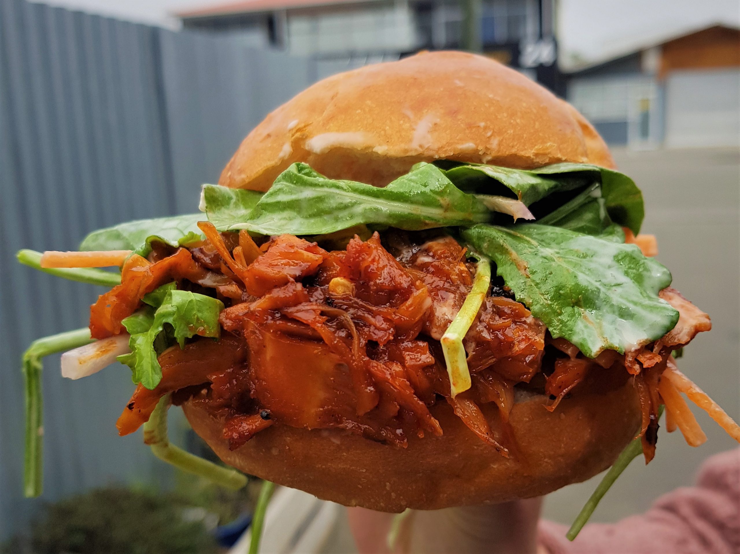 Jackfruit burger with gochujang BBQ sauce, tahini dressed greens, crunchy mustard potato salad.